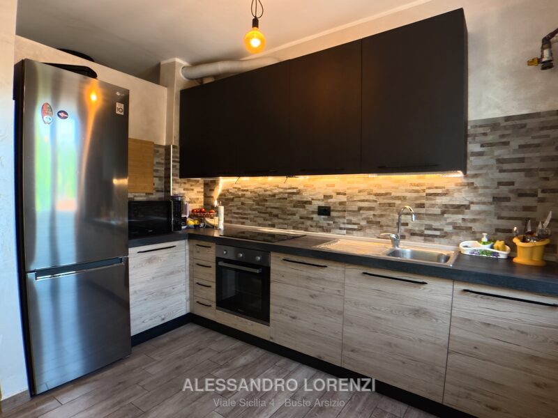 Cucina a vista con elettrodomestici in acciaio e piano cottura a induzione