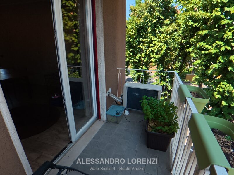 Balcone del soggiorno con vista sul verde e unità esterna del climatizzatore